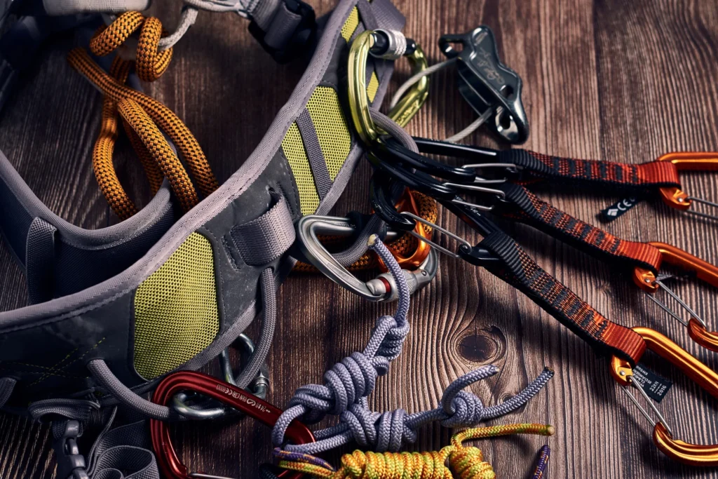 closeup shot many colorful climbing carabiners knots wooden surface scaled